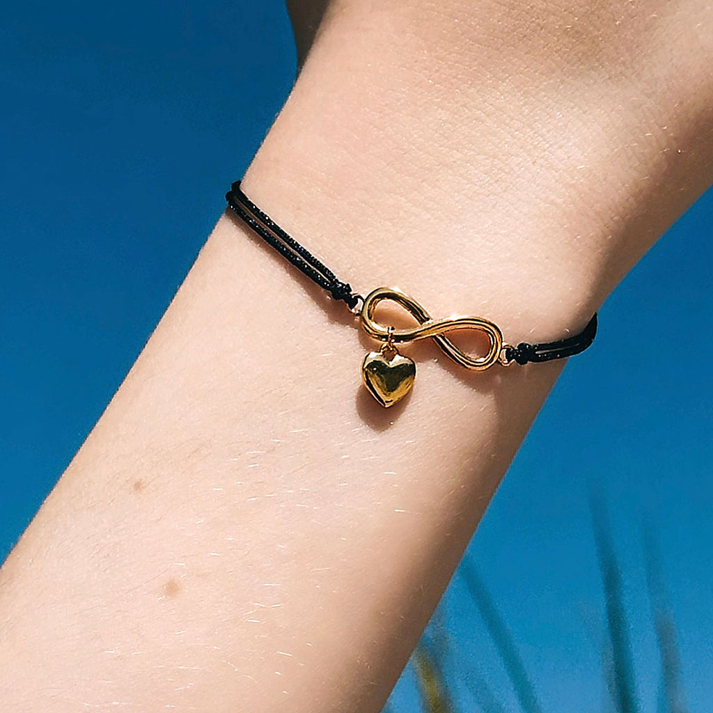 Silbernes Infinity-Armband mit Herzanhänger | vergoldet, an schwarzer Schnur