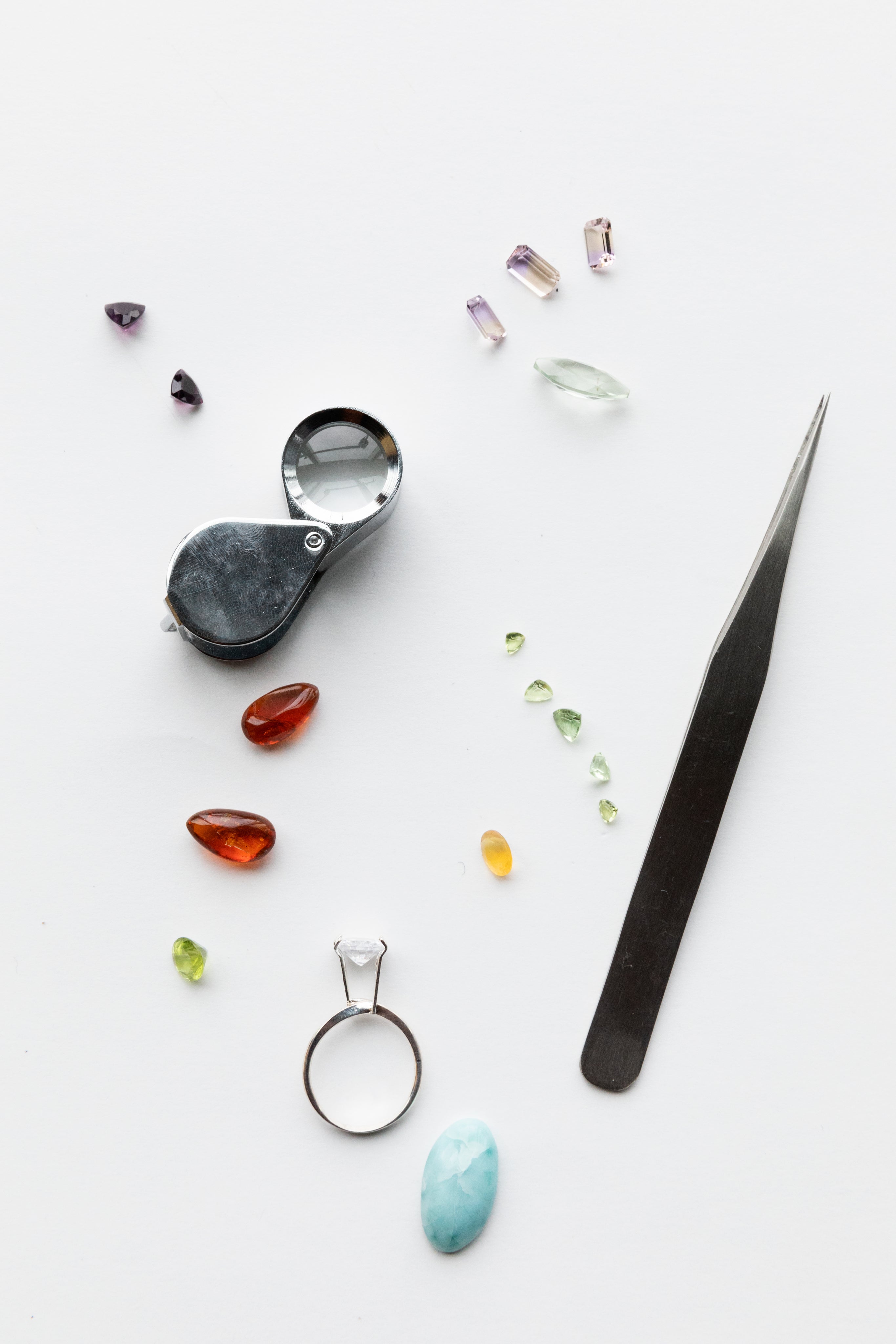 Silver Outlet Gemstones and Tools Laid on Table